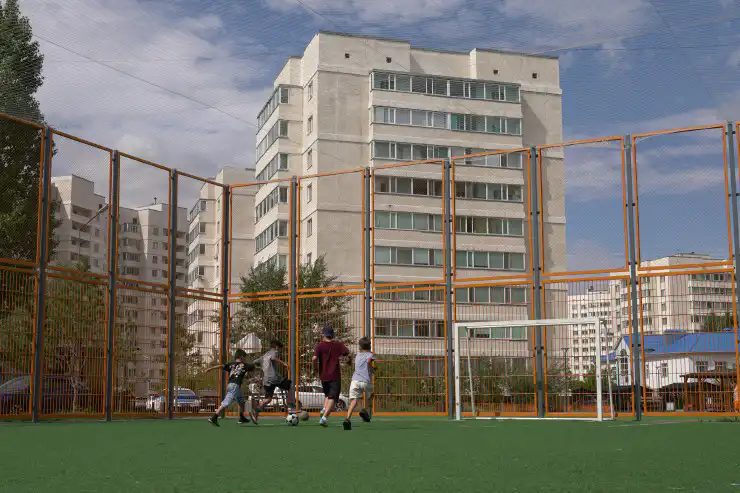 Дети играют в футбол на огороженном поле, Жагалау, Астана, 2025 год