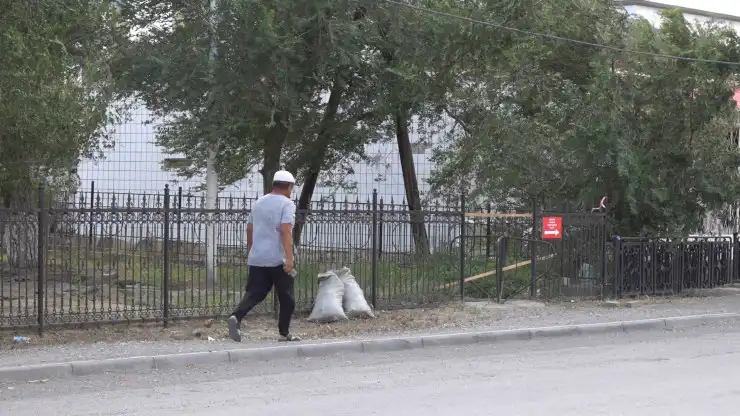 Человек идёт вдоль дороги в посёлке Достык, граница Казахстана и Китая