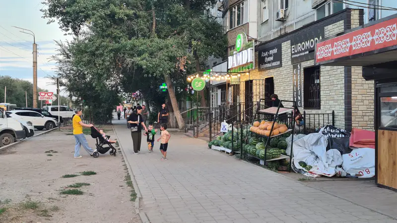 Женщина пытается закатить коляску на тротуар, Актобе, лето 2025 года