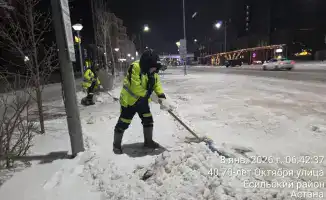 Дорожные рабочие Астаны убирают снег в зимних условиях