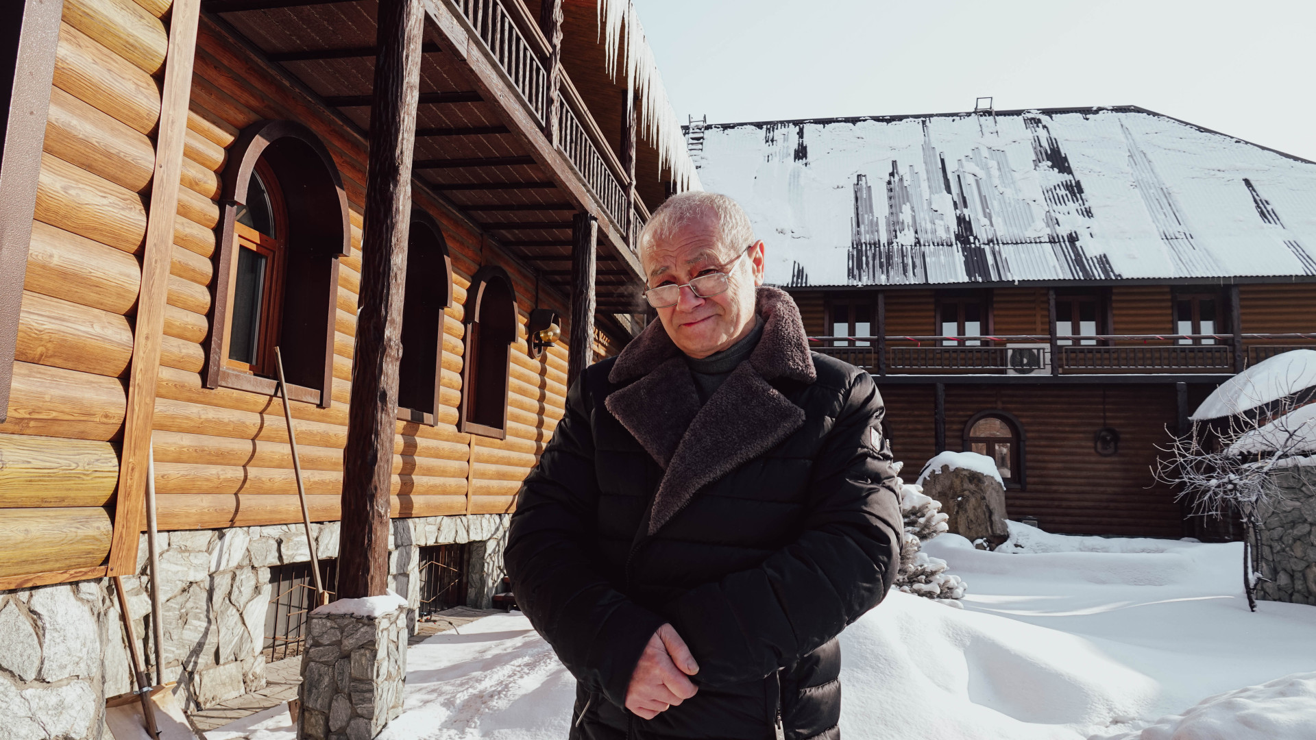 Юрий Костанянц на фоне своего дома-музея со скульптурами из дерева в Усть-Каменогорске